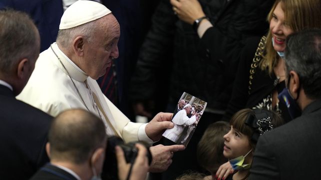 El Papa Francisco mira una foto de sí mismo que le presentó una niña al final de su audiencia general semanal en el Salón Pablo VI, en el Vaticano, el miércoles 10 de noviembre de 2021.