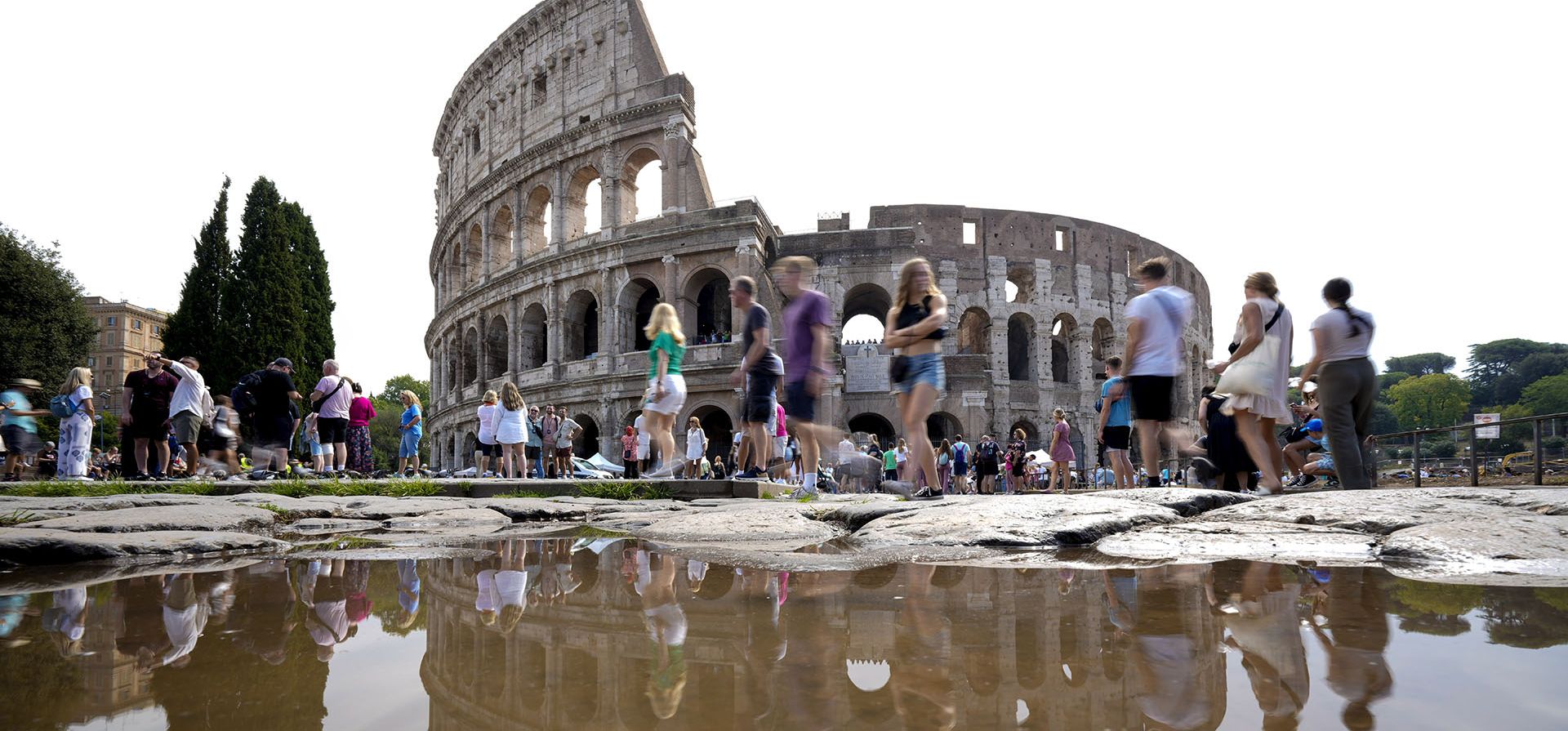 Turistas caminan junto al antiguo Coliseo romano, que se refleja en un charco, en Roma, el jueves 5 de septiembre de 2024. (Foto AP/Andrew Medichini)