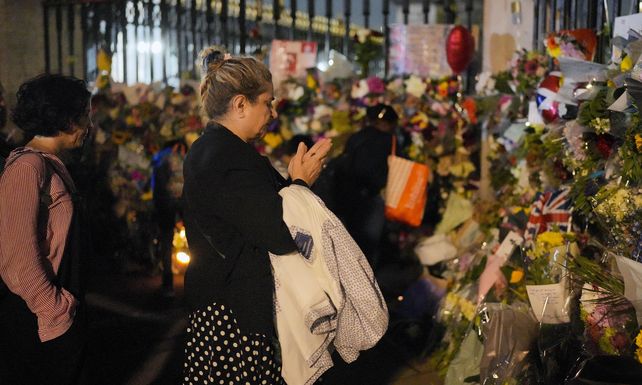 Dolor. Una mujer reza ante las rejas de Buckingham tapadas de flores y mensajes.&nbsp;