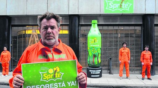 Pintan una botella de dos metros frente a Coca Cola contra los desmontes