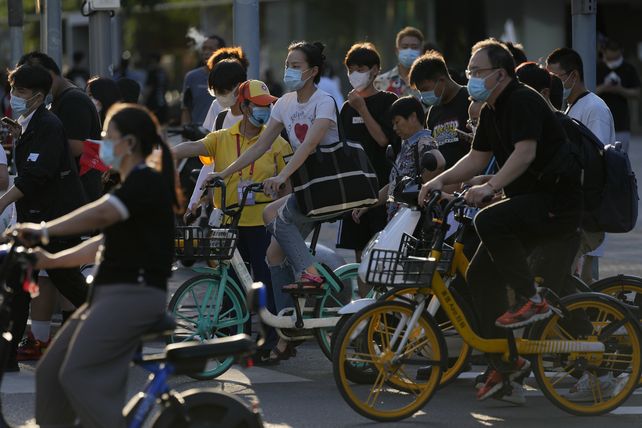 Ciclistas con barbijos este lunes en una calle de Beijing. Esta ciudad y otras 20 están bajo régimen de confinamiento.&nbsp;