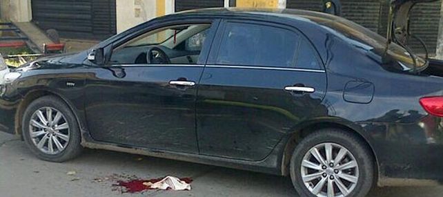 El Toyota Corolla que fue atacado por los motochorros. En el piso un trapo con sangre