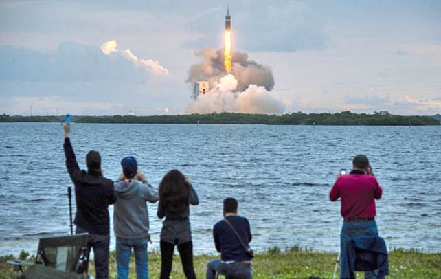 Espectadores saludan la partida del cohete lanzador Delta Heavy en Cabo Cañaveral (Florida).