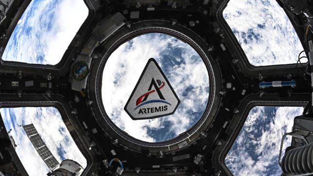 Un parche del programa Artemis flota en la cúpula de la Estación Espacial Internacional.