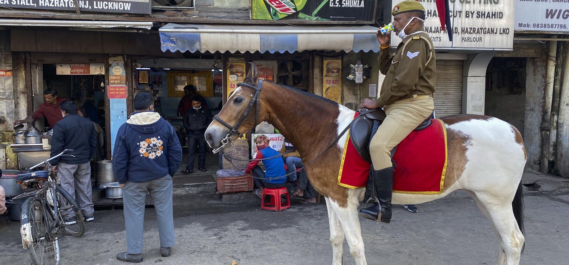 Un policía que patrulla a caballo por la mañana toma un descanso para el té en Lucknow, India, el miércoles 12 de enero de 2022.