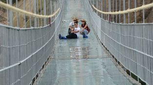 China inaugura un puente colgante de cristal sobre un precipicio a 180 metros de altura