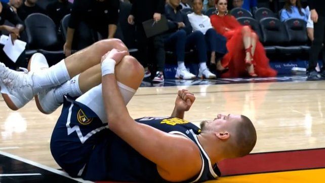 Nikola Jokic en el piso con dolor en su rodilla izquierda