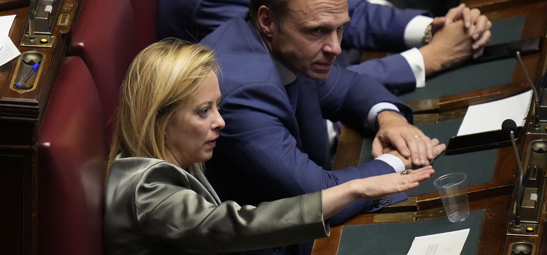 La líder italiana Giorgia Meloni, se sienta junto al miembro del partido Francesco Lollobrigida durante una sesión de votación del nuevo parlamento, para elegir al nuevo presidente de la Cámara, en Roma, el viernes 14 de octubre de 2022.