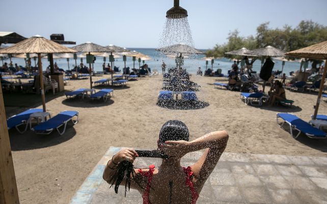 Una mujer se ducha en una playa de la aldea de Lagonissi