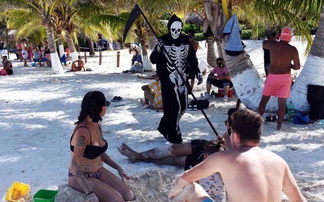 Una persona vestida de muerte, recorre la playa de Puerto Morelos, estado de Quintana Roo, México, en medio de la pandemia del coronavirus COVID-19.