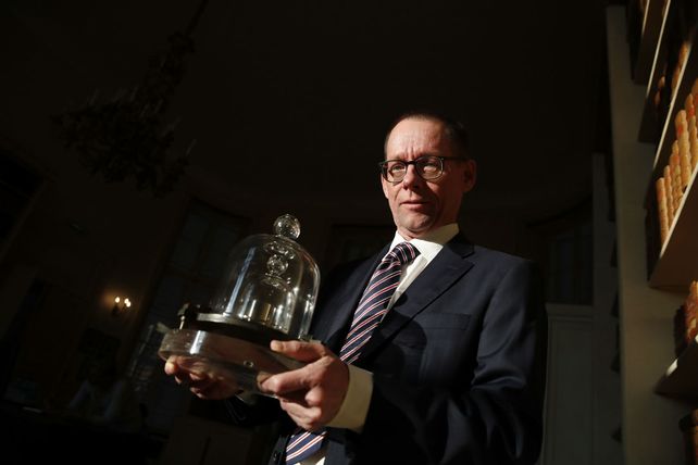 El titular de la Oficina Internacional de Pesos y Medidas muestra una réplica del kilogramo patrón.