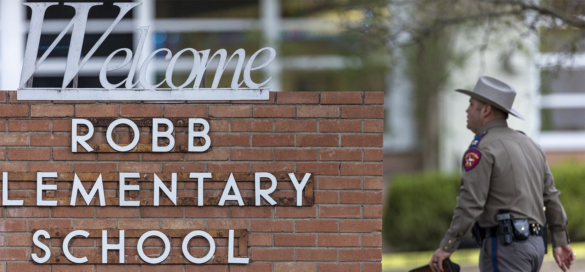 Un policía estatal pasa frente al letrero de la Escuela Primaria Robb en Uvalde, Texas, el martes 24 de mayo de 2022, luego de un tiroteo mortal en la escuela.