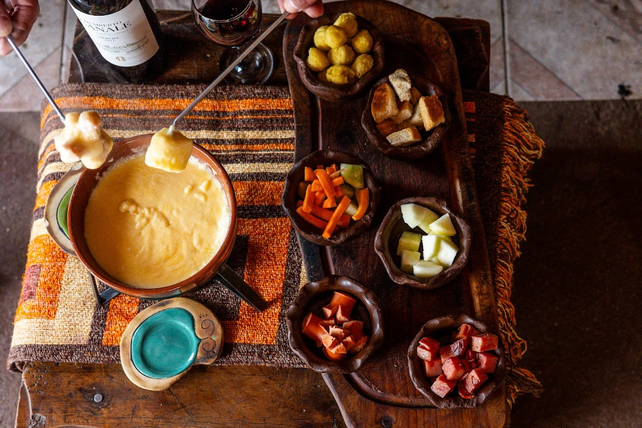 Fondue de quesos con distintas carnes y vegetales para sumergir