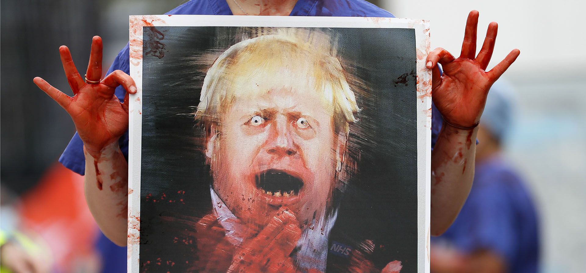 ARCHIVO - Una enfermera sostiene una pintura del primer ministro Boris Johnson aplaudiendo con sangre en sus manos como parte de una manifestación de trabajadores del NHS en hospitales de Londres para exigir un aumento salarial del 15 por ciento por parte del gobierno en Londres, el miércoles 26 de agosto. 2020. Los medios británicos aseguran que el primer ministro Boris Johnson acordó renunciar el jueves 7 de julio de 2022, poniendo fin a una crisis política sin precedentes sobre su futuro.