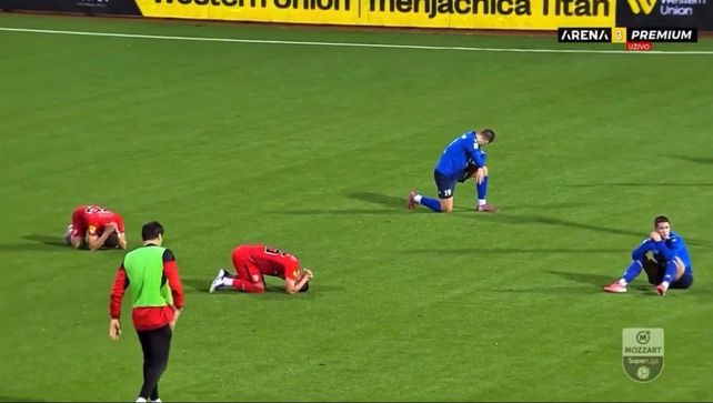 Los jugadores de ambos equipos caen desplomados al conocerse la muerte del director técnico Zizovic.