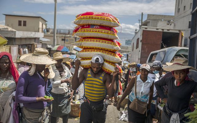 Un hombre transporta mercancías en un mercado callejero en Puerto Príncipe