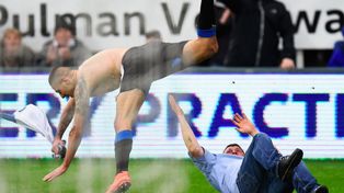 Un hincha ingresó a la cancha para festejar un gol pero resbaló en el peor momento