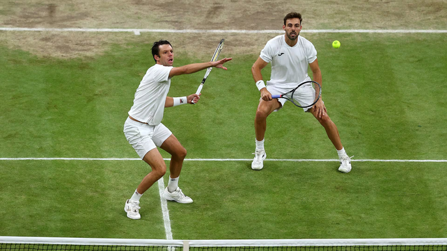 Horacios Zeballos prepara el revés y atrás mira Marcel Granollers. La pareja se despidió del torneo de tenis de Wimbledon.