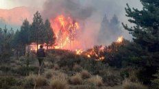 TRABAJO. Un operario emergencista, manguera en mano, corre a mojar los pastizales para contener las llamas.. TRABAJO. Un operario emergencista, manguera en mano, corre a mojar los pastizales para contener las llamas..