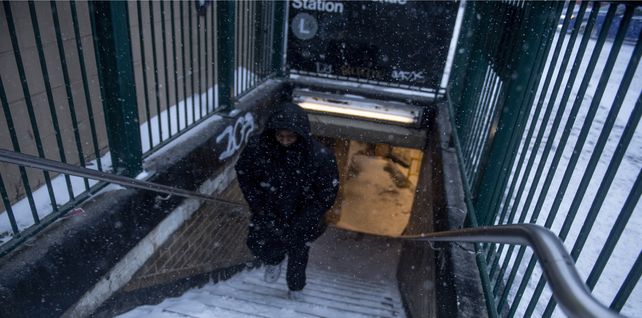 Un hombre sube las escaleras del metro cubiertas de nieve en la sección Bushwick del distrito de Brooklyn de Nueva York.