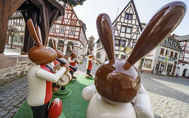 Figuras de madera de tamaño humano que representan conejitos de Pascua tocando música frente al histórico ayuntamiento de Michelstadt