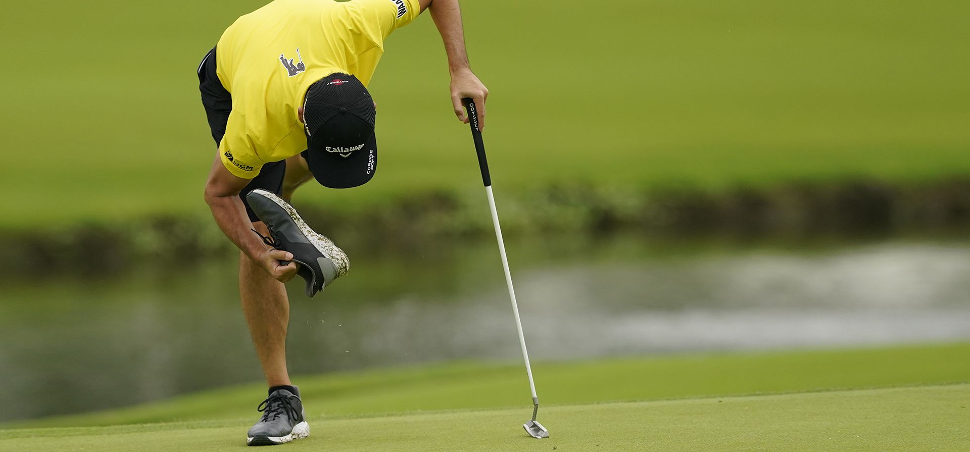 Kevin Na quita una piedra de su zapato en el green del hoyo 16 durante una ronda de práctica para el campeonato de golf de la PGA, el martes 17 de mayo de 2022 en Tulsa, Oklahoma.