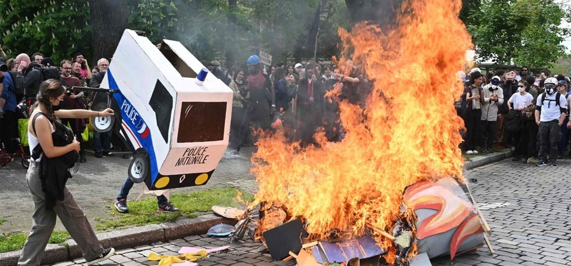 Manifestantes arrojan un furgón policial de cartón al fuego mientras participan en una manifestación el Primero de Mayo frente al Parlamento en Estrasburgo. (Foto de Frederick FLORIN / AFP)