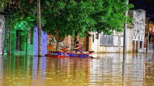 Calle Carriego y Costanera está bajo agua y los vecinos acceden en botes para cuidar sus viviendas.