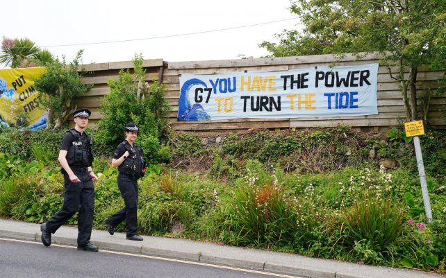 Los agentes de policía pasan junto a una pancarta en Carbis Bay. Fotografía: Aaron Chown / PA