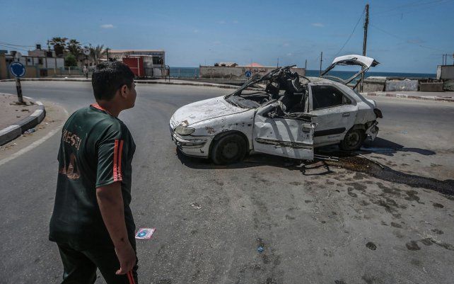 Un niño palestino observa un automóvil que fue alcanzado por un ataque aéreo israelí, cerca de la playa en la ciudad de Gaza.