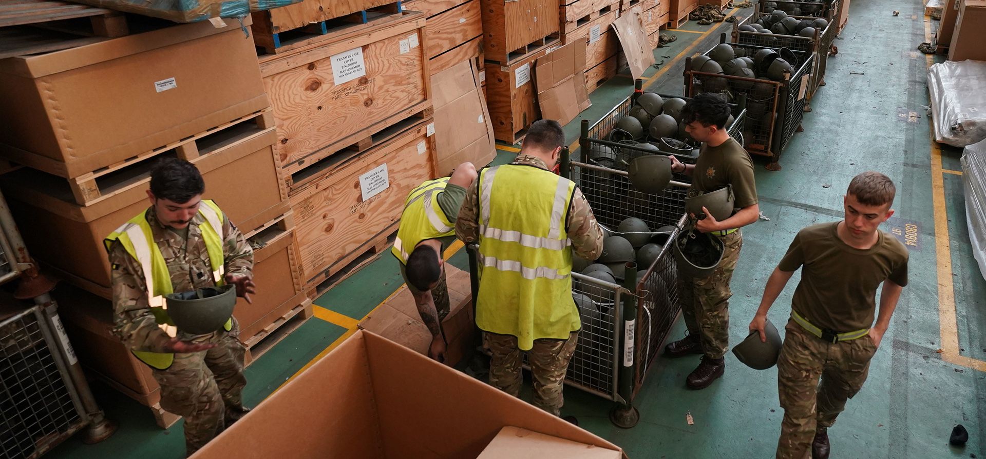 Miembros del ejército empacan miles de cascos excedentes donados por el ejército para