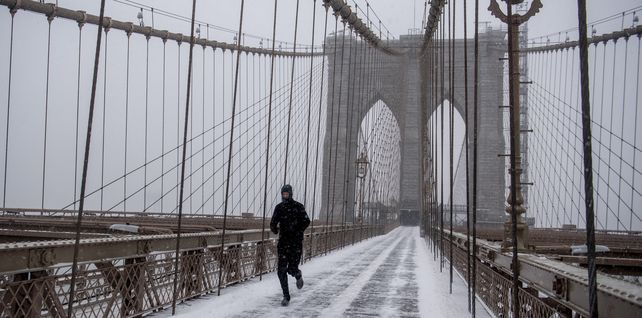 Un hombre trota por el puente de Brooklyn durante la tormenta de nieve en Nueva York. Una poderosa tormenta del noreste barrió la costa este , amenazando con enterrar partes de 10 estados bajo una nieve profunda.