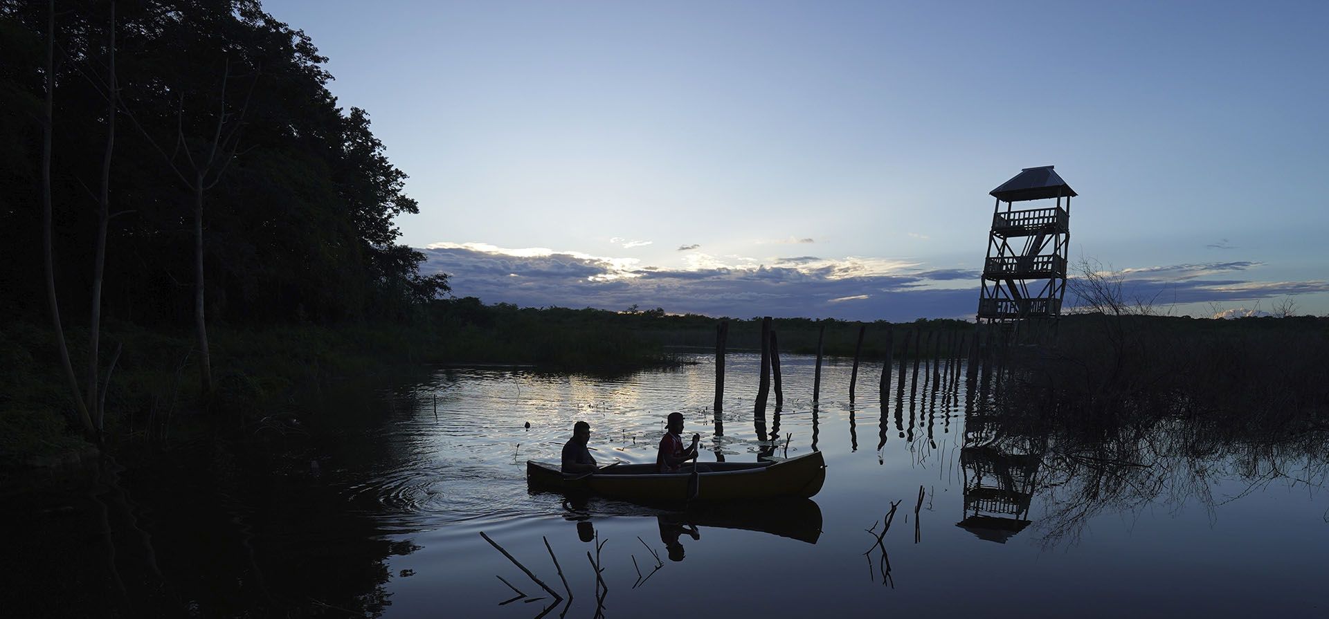 Dos personas reman en un lago en las tierras de cultivo comunales de Valentín Gómez Farías cerca de la Reserva de la Biosfera de Calakmul en la península de Yucatán en México. Los residentes crearon un proyecto de ecoturismo hace nueve años que tiene a los visitantes alojados en tiendas de campaña bajo techos de palma tejida. (Foto AP/Marco Ugarte)