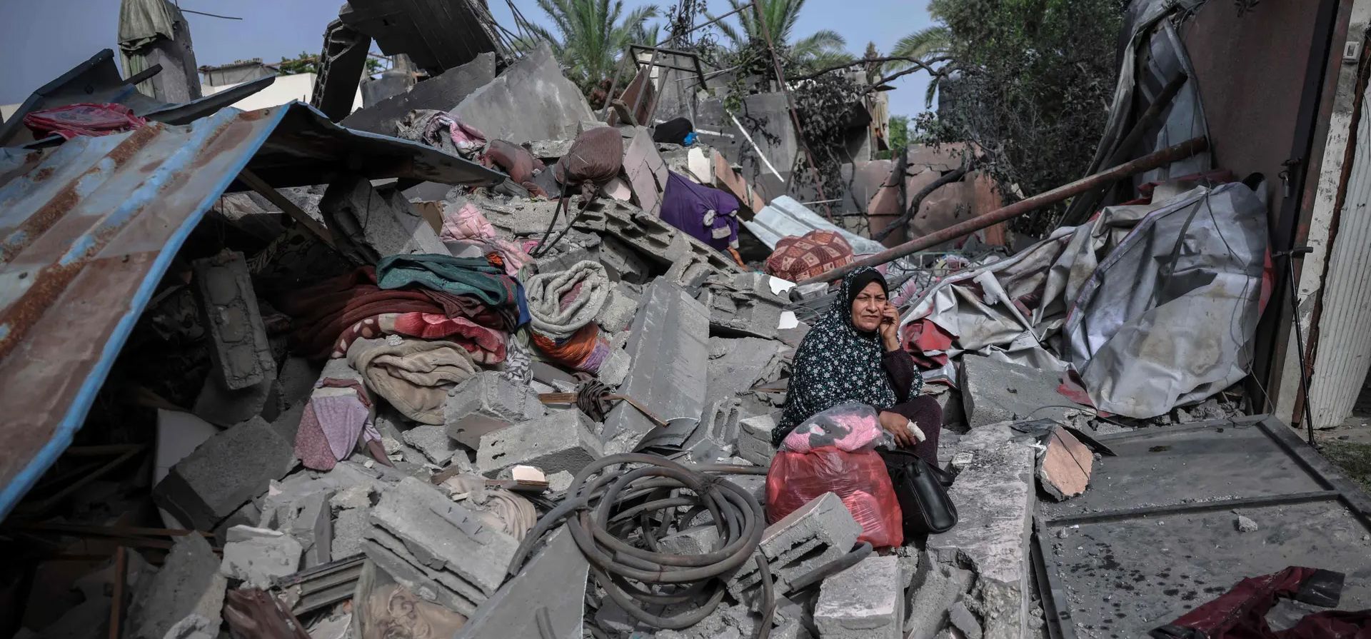Beit Hanoun, Franja de Gaza. Una mujer sentada entre los escombros de un edificio golpeado en un ataque aéreo israelí espera ayuda. Fotografía: Mohammed Abed/AFP/Getty Images