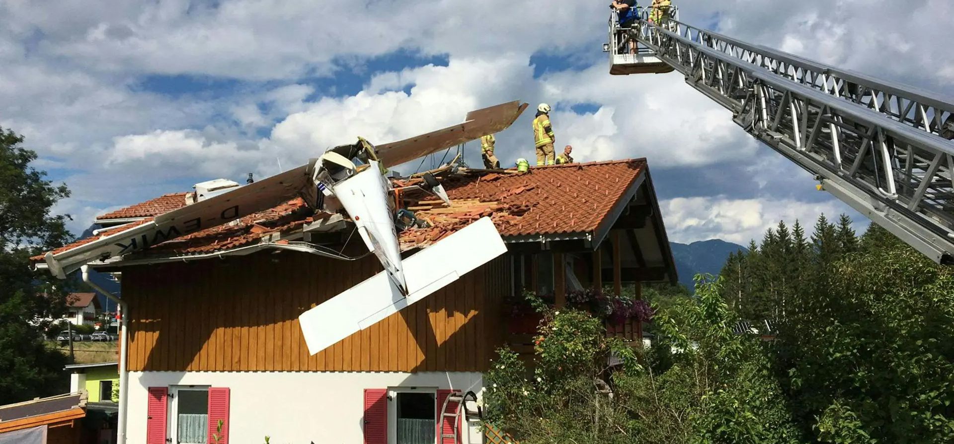Bomberos trabajan en el techo de una casa después de que un pequeño avión se estrellara contra ella en Höfen, Austria  Dos personas heridas fueron recuperadas del incidente. Fotografía: APA/AFP/Getty Images
