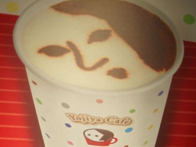 Un café con caras humanas dibujadas en la espuma