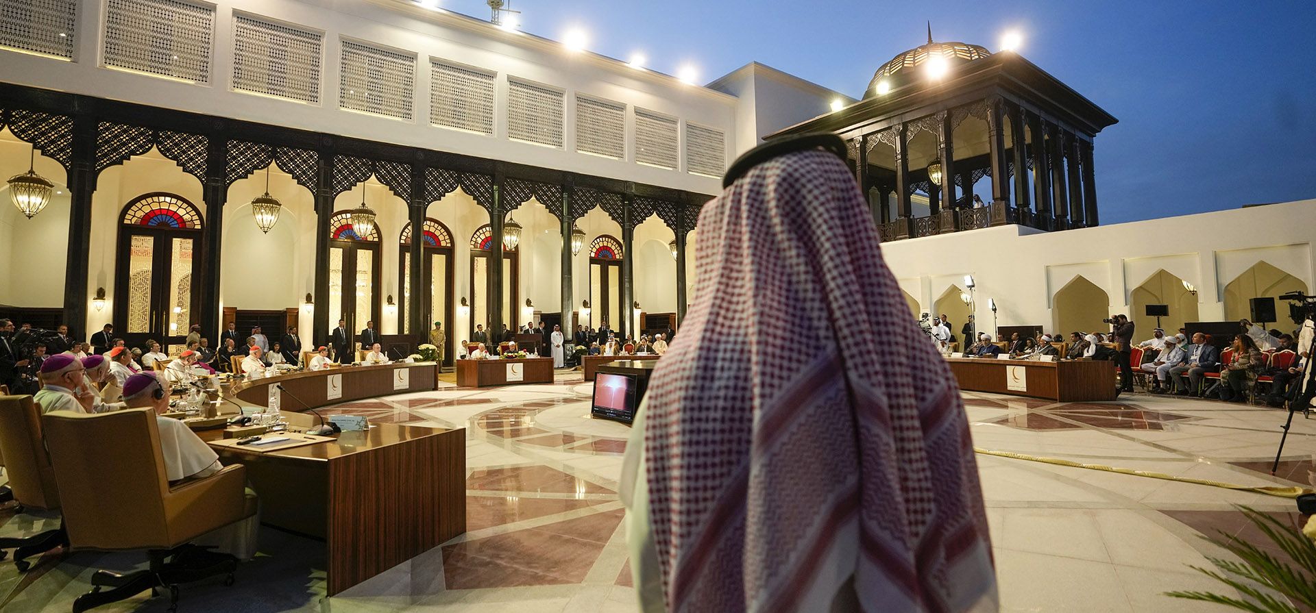 Un hombre observa cómo el Papa Francisco y Ahmed El-Tayeb, Gran Imán de al-Azhar, asisten a una reunión con los miembros del Consejo Musulmán de Ancianos en la Mezquita del Palacio Real de Sakhir, Bahréin, el viernes 4 de noviembre de 2022. El Papa Francisco realiza una visita desde el 3 al 6 de noviembre para participar en una conferencia patrocinada por el gobierno sobre el diálogo Este-Oeste.