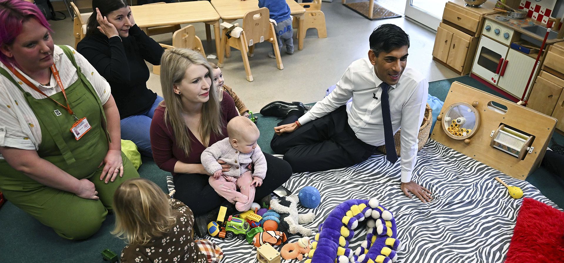 El primer ministro británico, Rishi Sunak, a la derecha, participa en una actividad de "permanecer y jugar" durante una visita a un centro familiar con su esposa Akshata Murty, en St Austell, Cornwall, suroeste de Inglaterra, el jueves 9 de febrero de 2023. ( Ben Stansall/Foto de la piscina vía AP)