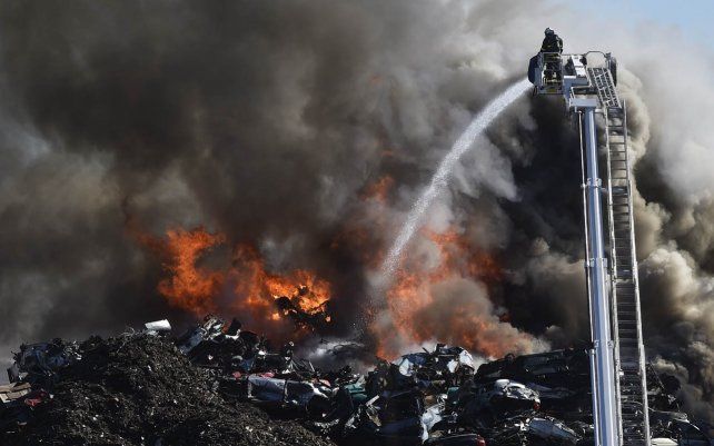 Un bombero intenta apagar un incendio en un gran depósito de autos deshuasados, Ostrava, República Checa.