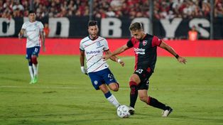 Martino encara ante la marca de Leguizamón en un partido de mucha intensidad. Newells y San Lorenzo empataron 2 a 2 en el Coloso.