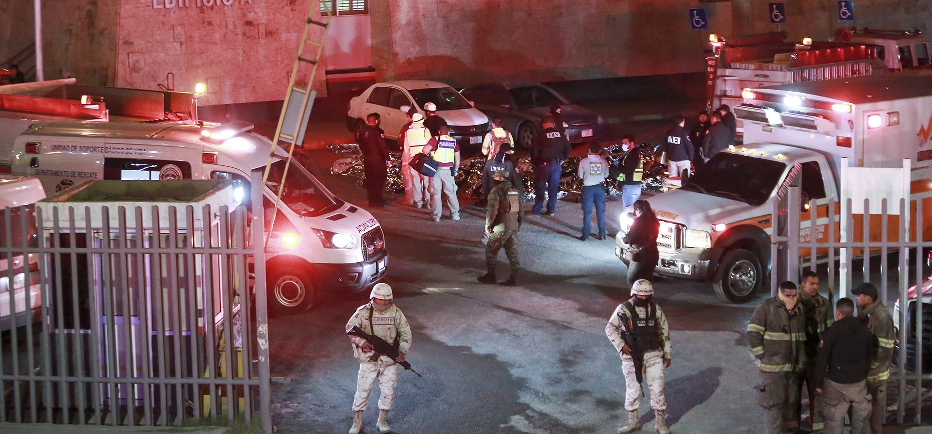 Paramédicos y fuerzas de seguridad trabajan entre los cuerpos cubiertos de migrantes que murieron en un incendio en un centro de detención de inmigrantes en Ciudad Juárez, México, el martes 28 de marzo de 2023. (Foto AP/Christian Chavez)