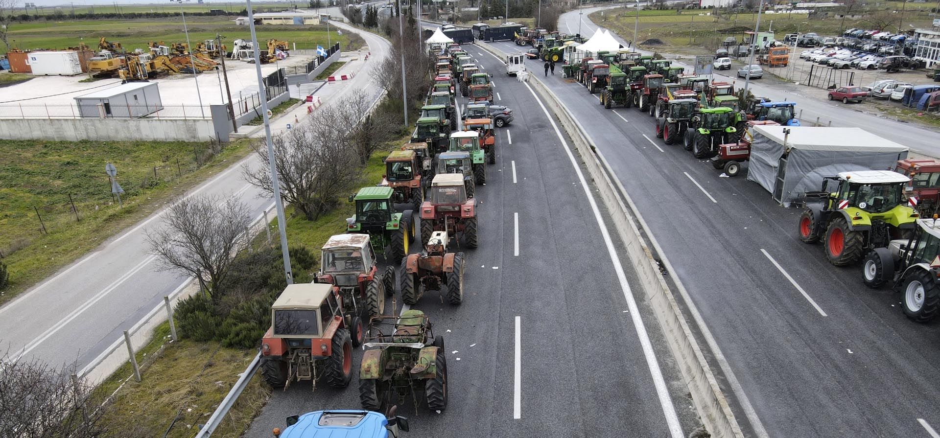 Agricultores con sus tractores se reúnen en una carretera nacional durante una protesta en la ciudad de Tyrnavos, en el centro de Grecia. Economistas, agricultores y trabajadores y organizaciones sindicales están de acuerdo sobre una crisis del costo de vida en Europa: la inflación puede disminuir más tarde este año, pero el impacto del aumento de los precios de los alimentos y la energía perdurará.