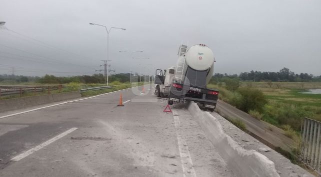 Un camión reventó una goma y quedó colgado en un puente de la 168