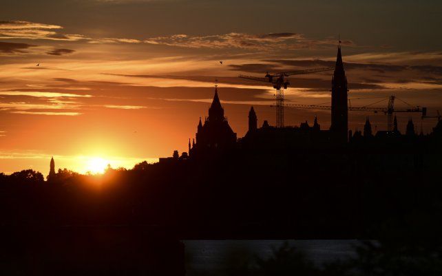 Un eclipse solar anular se eleva sobre las grúas de construcción y la Torre de la Paz en Parliament Hill, Ottawa, Canadá.