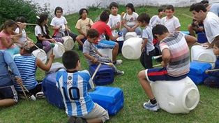 Con bidones y palillos, chicos de tres barrios aprenden percusión