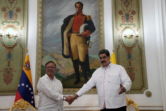 Los mandatarios se saludan en el Palacio Miraflores debajo de un retrato del héroe Simón Bolivar.