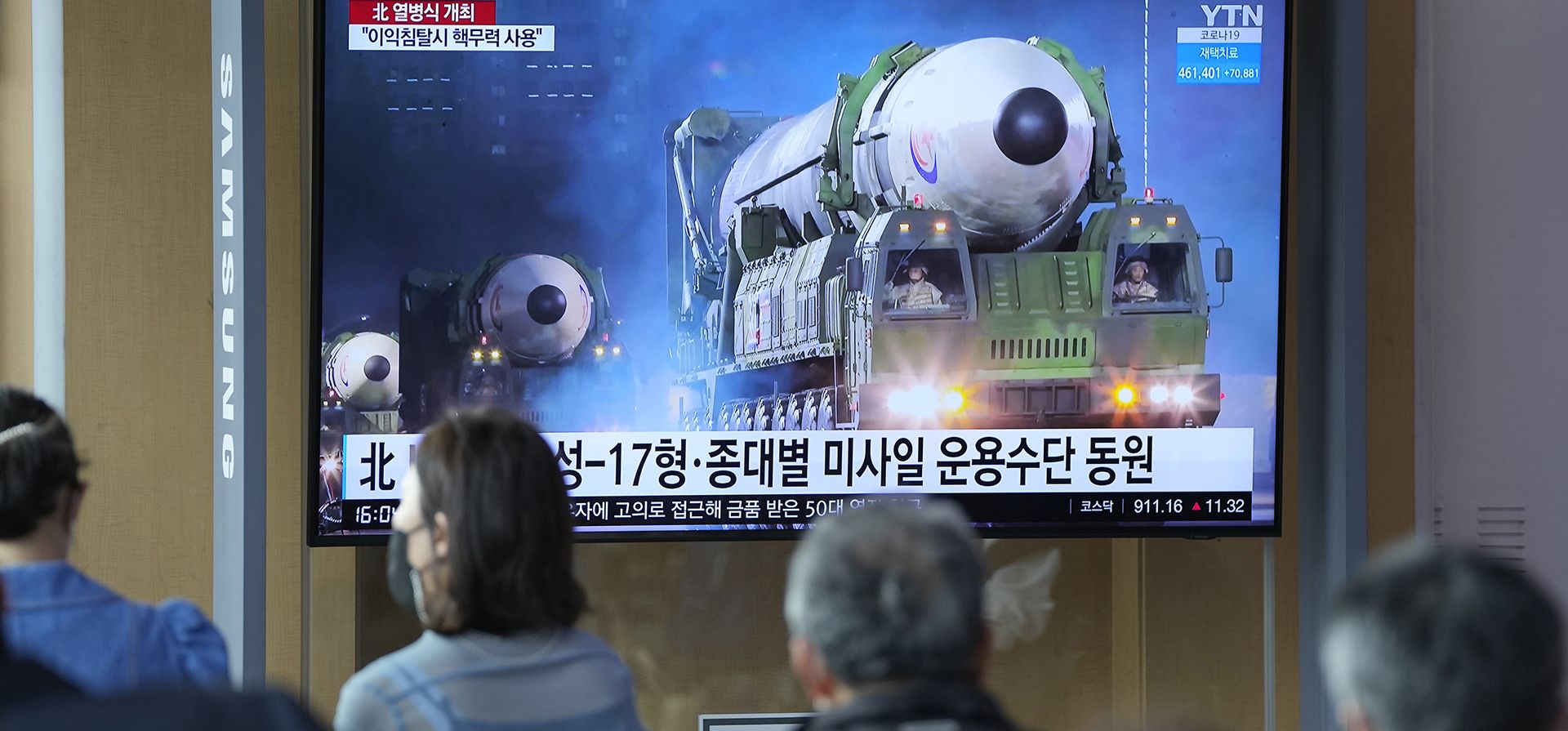 Gente mira una pantalla de televisión que muestra un programa de noticias que informa sobre el desfile militar de Corea del Norte con una imagen en una estación de tren en Seúl, Corea del Sur, el martes 26 de abril de 2022. El líder norcoreano, Kim Jong Un, prometió avanzar más rápido para reforzar sus fuerzas nucleares y amenazó con usarlos si lo provocaban.