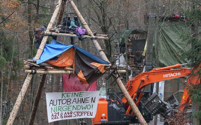 Activistas se sientan en un marco de tres patas en el bosque de Dannenroeder
