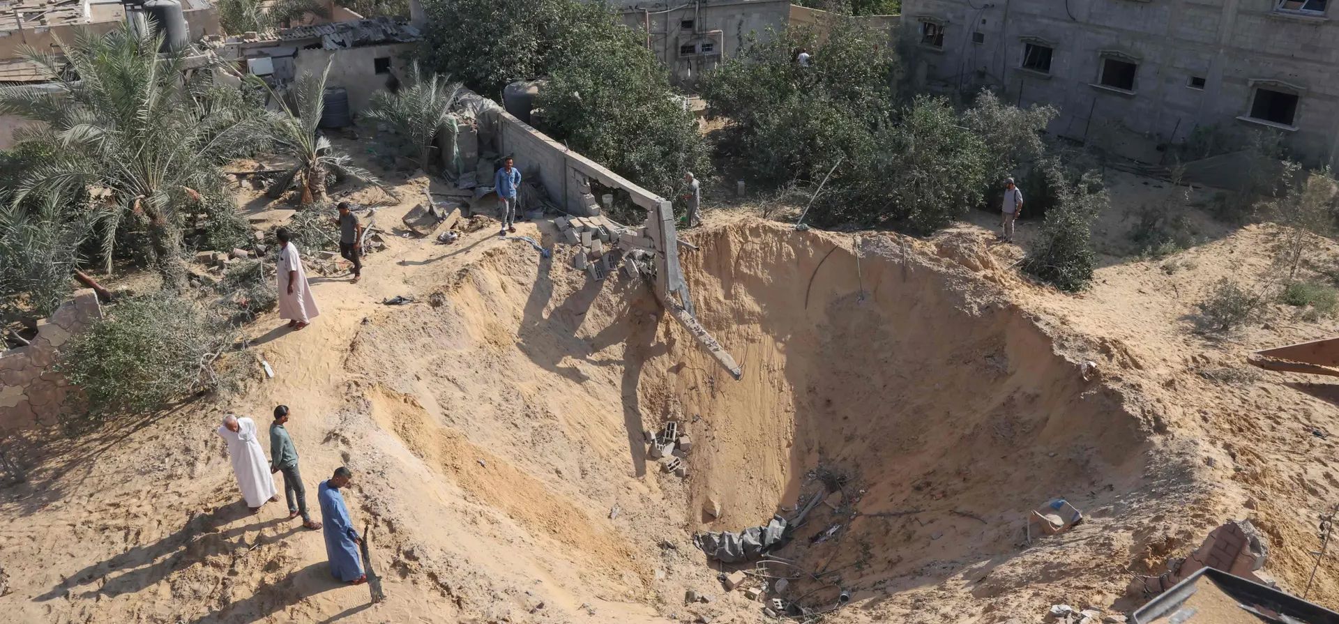 Palestinos inspeccionan un cráter tras tres días de conflicto con Israel, en Rafah, Franja de Gaza. Fotografía: Said Khatib/AFP/Getty Images