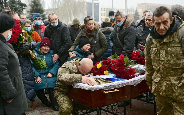 Familiares y amigos lloran desconsoladamente en el sepelio de un militar de 37 años que fue asesinado a tiros por un francotirador cerca de la aldea de Pisky en la región de Donetsk. Foto: - / Ukrinform / dpa